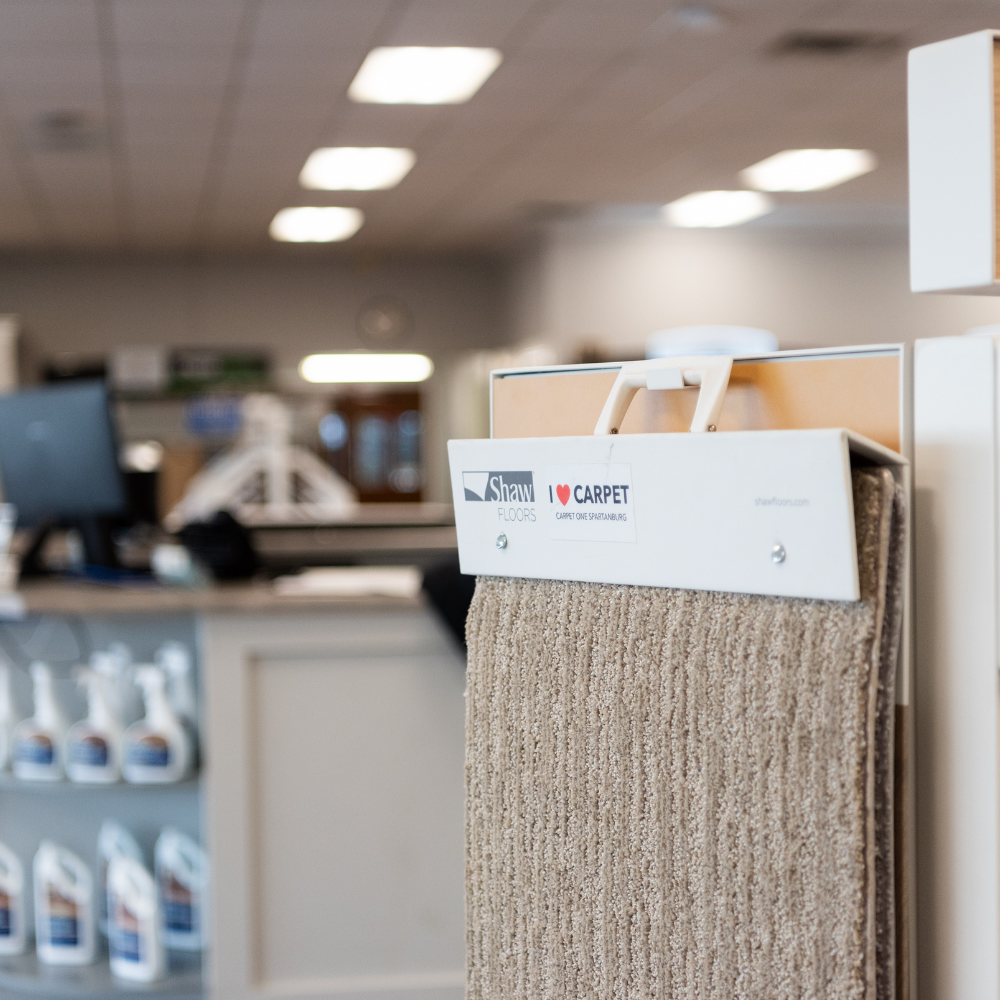 Beige carpet sample on display in a flooring showroom.